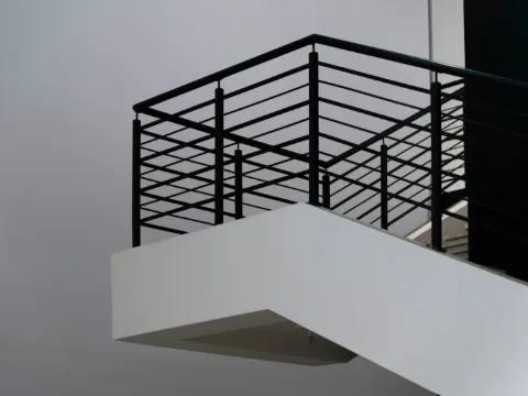 Garde-corps à lisses horizontales en acier noir au bord d'un escalier blanc contemporain