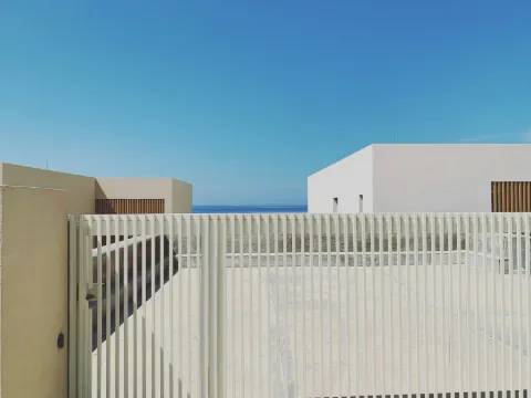 Portail contemporain à lames verticales claires devant des maisons cubiques blanches et la mer